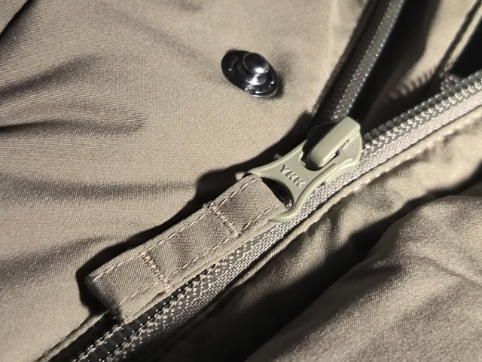The metallic scrape of the zipper teeth locking together