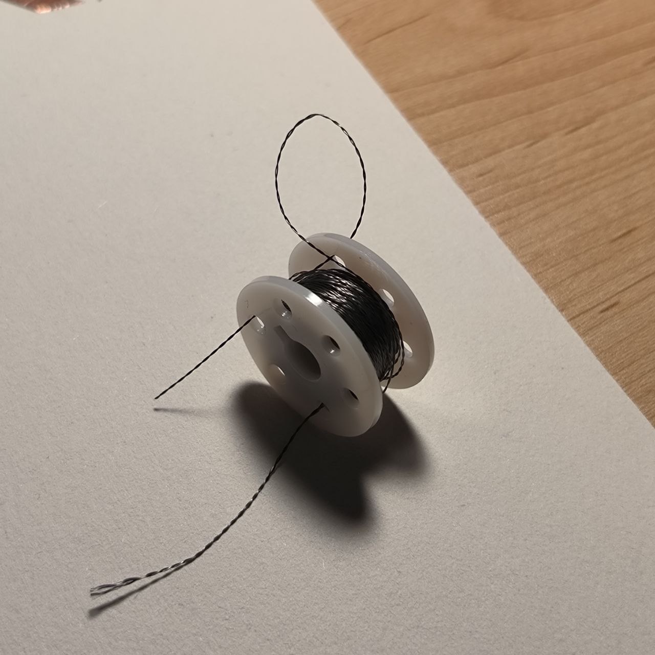 The first image shows a spool of conductive thread. This special material allows electricity to flow through fabric or soft materials, enabling the creation of soft circuits. It’s commonly used in wearable technology for its flexibility.