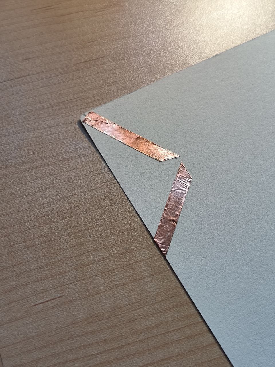 Copper tape is applied over the sketched lines, turning the paper into a conductive surface. These strips will act as contact points to trigger different commands through the Makey Makey.

      